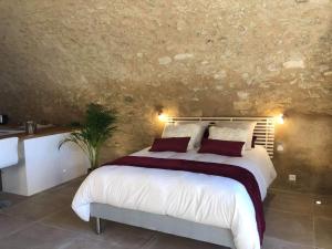 ReillanneParadise Love In Provence - loft en pierres - spa privatif的卧室配有一张白色的大床和石墙