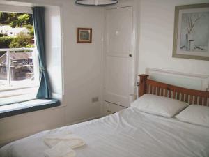 卡桑德Balcony Cottage的卧室配有白色的床和窗户。