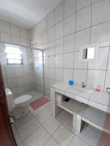 佩鲁伊比Maranata Suítes - 2 minutos de carro até o mar的白色的浴室设有卫生间和水槽。