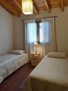波特雷里约斯Remanso de las Acacias - Potrerillos的一间卧室设有两张单人床和一个窗户。