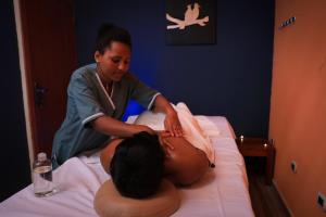 拉利贝拉Mezena Resort & SPA的女人在床上享受按摩