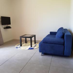 普纳奥亚Le Tiki Rouge的客厅配有蓝色的沙发和桌子