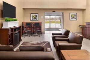 密尔沃基Hawthorn Suites By Wyndham Oak Creek/Milwaukee Airport的带沙发和平板电视的等候室