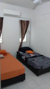 班吉Affordable Stay @ Rue’s Villa Tropika Apartment, UKM Bangi的一间卧室设有两张床、一个加热器和窗户。