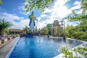 坎古KTS Balinese Villas的一座大型游泳池,其背后是雕像