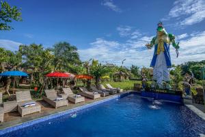 坎古KTS Balinese Villas的一座位于度假村内的游泳池,该度假村拥有一座雕像