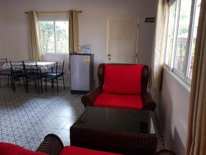 乌隆他尼纳迪度假屋的客厅配有红色的沙发和桌子