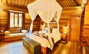蓝梦岛The Akah Cottage - CHSE Certified的一间卧室配有一张带天蓬的床