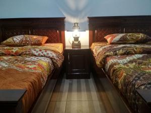 庞越KOPIKUIN bromo homestay的一间卧室设有两张床和一张桌子上的台灯。