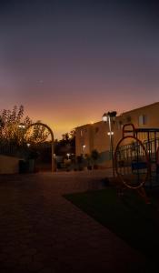阿哈达Seven Garden Alhada Suites的公园内的游乐场,背景是日落