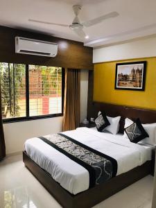 孟买Hotel Crystal Luxury Inn- Bandra的一间卧室设有一张大床和一个窗户。