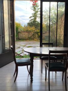 吉维尼Le studio du botaniste的窗户客房内的桌椅