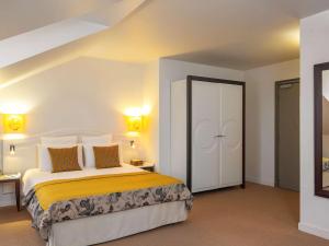 朗布依埃朗布依埃水星城堡酒店的一间卧室配有一张黄色和白色床单