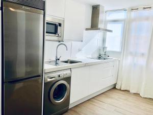 加的斯Apartamento Ecuador的厨房配有不锈钢冰箱和水槽