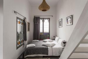 丹吉尔Riad Dar-tus的一间卧室配有带白色床单和枕头的床。
