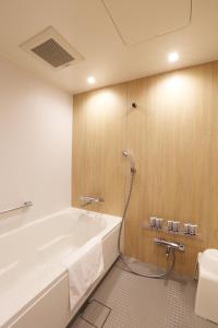 金泽Henn na Hotel Kanazawa Korimbo的带浴缸和卫生间的浴室。