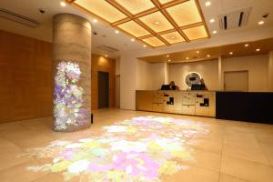 金泽Henn na Hotel Kanazawa Korimbo的大堂的地板上装饰着花卉壁画
