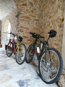 CaravonicaCasa Mariella citra 08012-lt-0004的两辆自行车停在石墙旁边