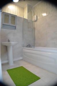 曼彻斯特Gorton Mount Hotel Manchester的带淋浴、盥洗盆和浴缸的浴室