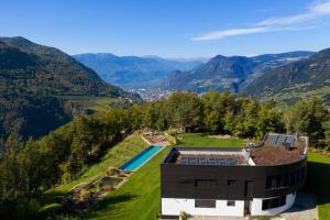 博尔扎诺VILLA COLLINA VERDE的享有带游泳池和山脉的房屋的空中景致