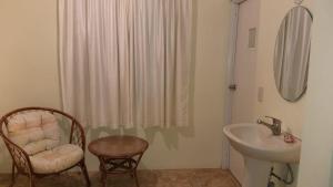 博卡奇卡Hotel Magic Tropical的一间带水槽、椅子和淋浴的浴室