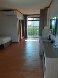 亚兰Baan Anong Hotel的带厨房的房间和一间带一张床的卧室