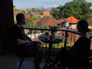 乌布Kampung Sari Homestay的坐在城市外景阳台上的男人和女人