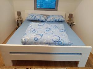 斯科普里FLAMANITA APARTMENTS的一张带蓝色和白色床单及枕头的床