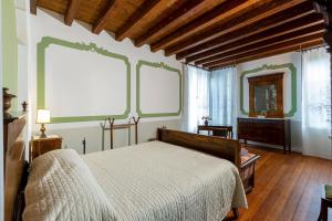 PolcenigoPalazzo Scolari的一间卧室设有一张床和两个大窗户
