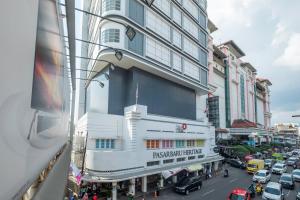 万隆SUPER OYO Collection O Hotel Pasar Baru Heritage的一条繁忙的城市街道,汽车停在大楼前