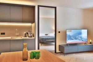 沃瑟姆阿尔伯格Warth52-W52 Apartments的带电视的客厅和卧室