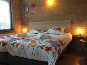 诺德克豪特Bungalow 221的一间卧室配有一张带鲜花的大床