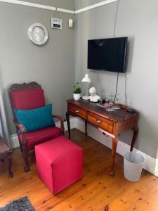 彼得马里茨堡Casa Mia的客厅配有电视、椅子和桌子