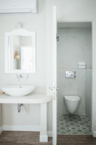 波罗斯Odyssey Suites的白色的浴室设有水槽和卫生间。