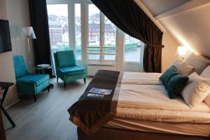 斯塔万格斯卡恩布莱格号角集品酒店的一间卧室配有一张床、两把椅子和一个窗户