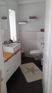 滕宁Huus Utspann的白色的浴室设有水槽和卫生间。