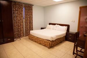 阿哈达Seven Garden Alhada Suites的一间卧室配有带白色床单和枕头的床。