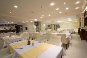 巴尼亚卢卡塔利亚酒店的一间设有白色桌子和白色椅子的餐厅