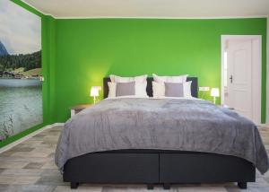 哈伦贝格Haus Jungmann的一间卧室设有一张大床和绿色的墙壁