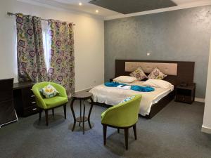 布拉柴维尔Capital Hôtel的卧室配有一张床和一张桌子及椅子