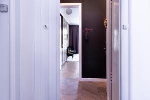 萨格勒布Tesla Design Apartments Zagreb的走廊上设有黑色的墙壁和白色的门