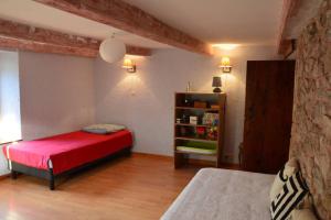 Rochessongîte de la cheneau的一间卧室设有红色的床和书架
