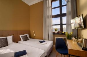 埃尔布隆格Apartamenty Oliwka的一间卧室设有两张床、一张桌子和一个窗口。