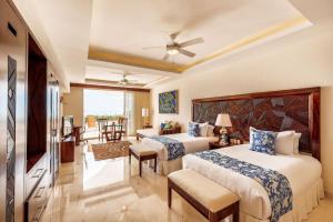 巴亚尔塔港Grand Miramar All Luxury Suites & Residences的酒店客房设有两张床和一个阳台。