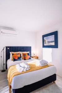 波尔图BBA Apartments Palácio I - Douro View & Parking的一间卧室配有一张带橙色和蓝色枕头的大床