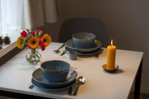 斯霍尔Studio Zonnehoek Schoorl的一张桌子,上面放着四个碗,还有蜡烛和鲜花