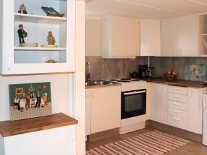 HarplingeHoliday home HARPLINGE II的厨房配有白色橱柜和水槽