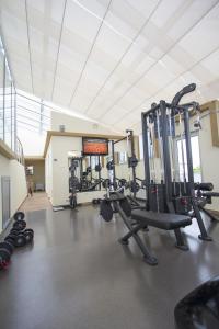 巴尼亚卢卡塔利亚酒店的一间健身房,里面装有几台跑步机和举重器材