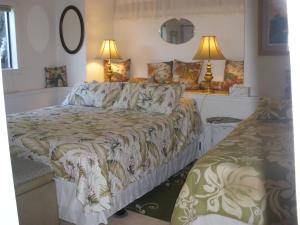 库克船长Belle Vue Kona Inc的一间卧室配有一张大床和两盏灯。