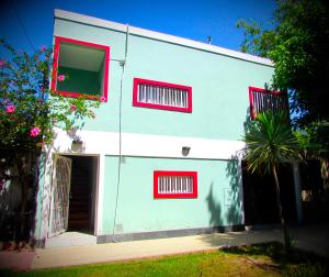 门多萨Departamento Encantador monoambiente Domaine Laborde I的白色的建筑,有红色的窗户和门